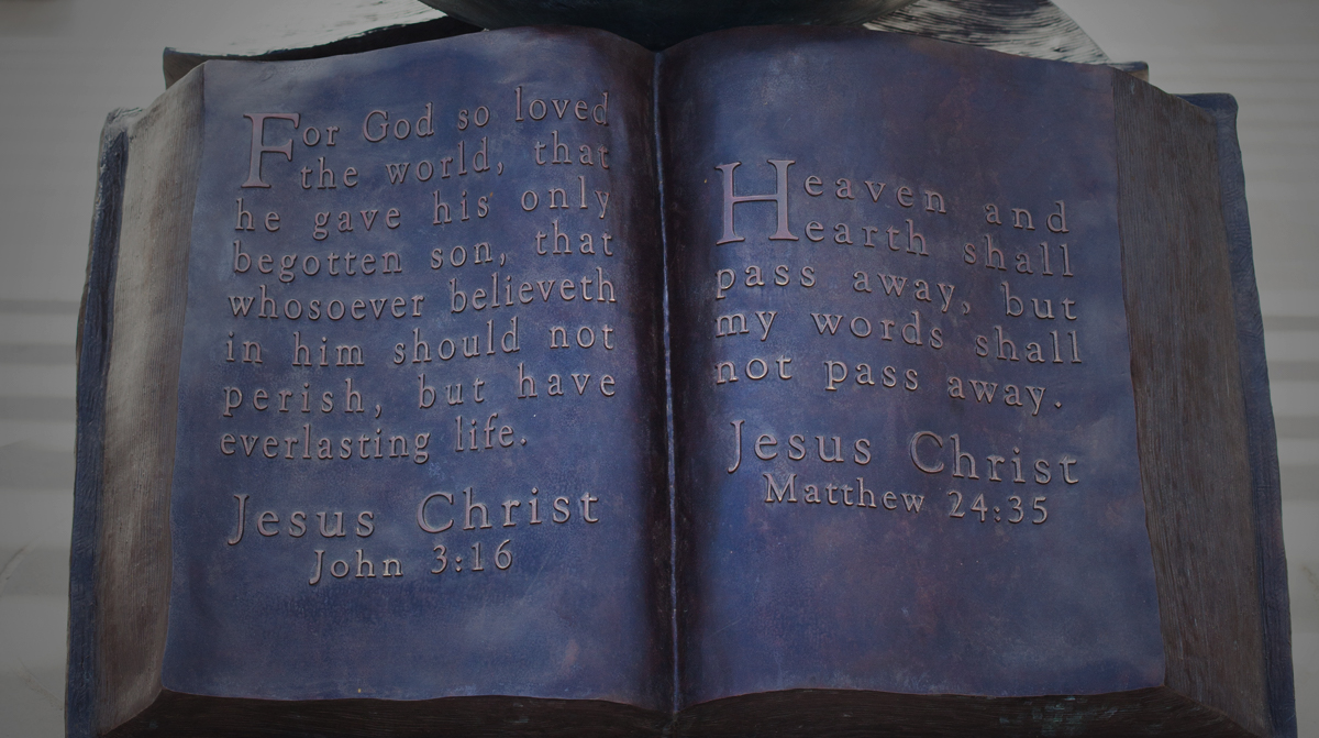 Bible sculpture of metal with a bible verse on it.